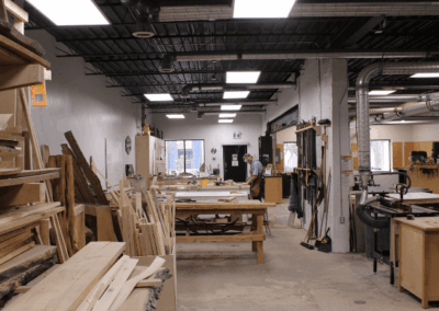 The woodshop interior after renovation with large wooden shelves, wooden tables, work stations, and equipment